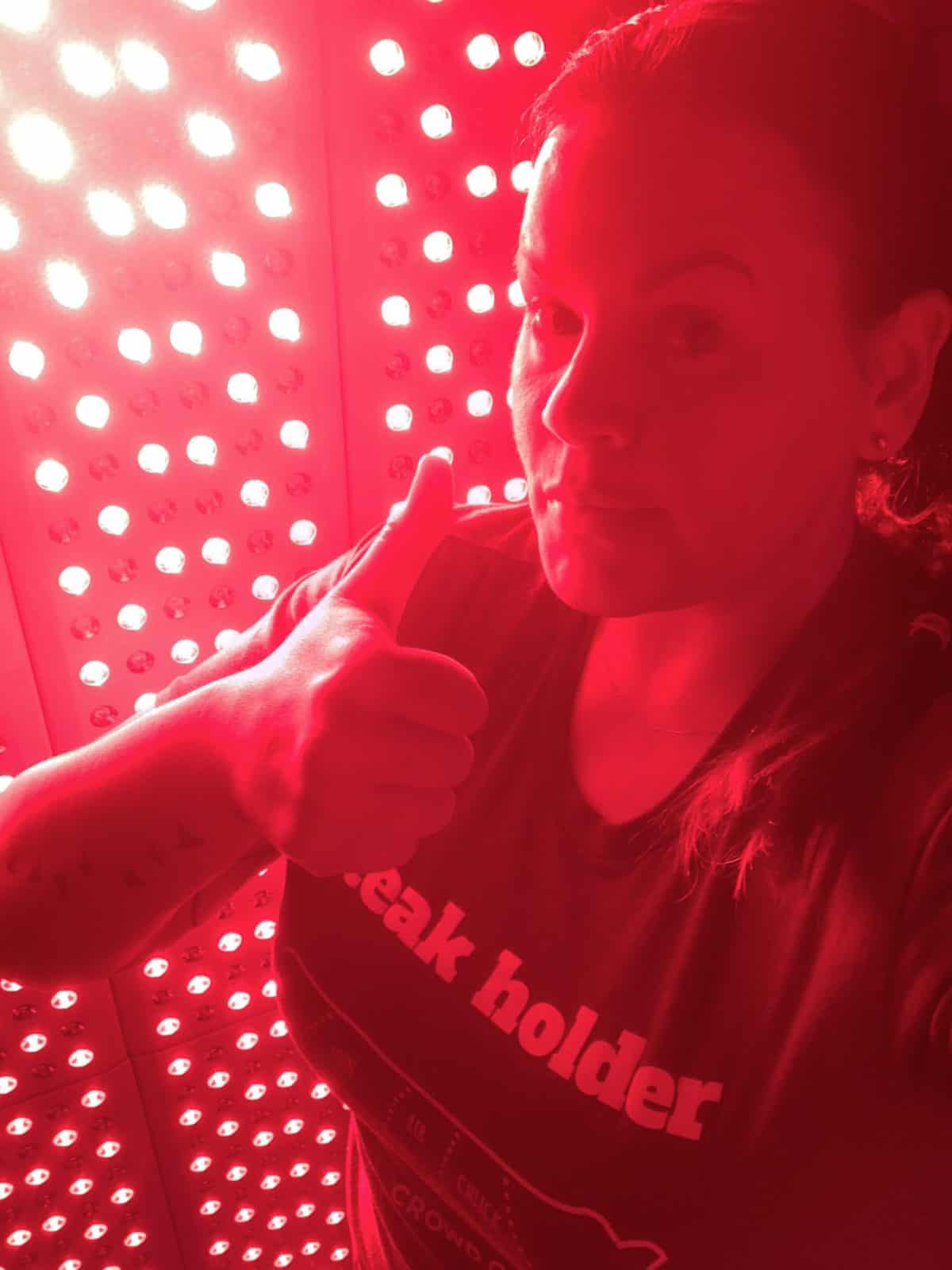 Woman standing in front of a Joovv Elite Red Light Therapy Unit