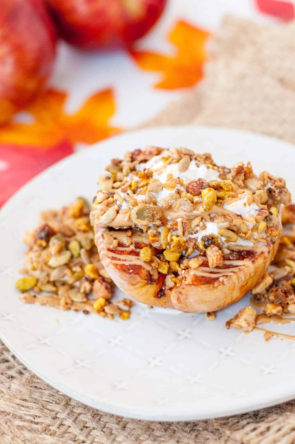 Baked Apple topped with granola, peanut butter, and whipped cream, surrounded by fall decorations