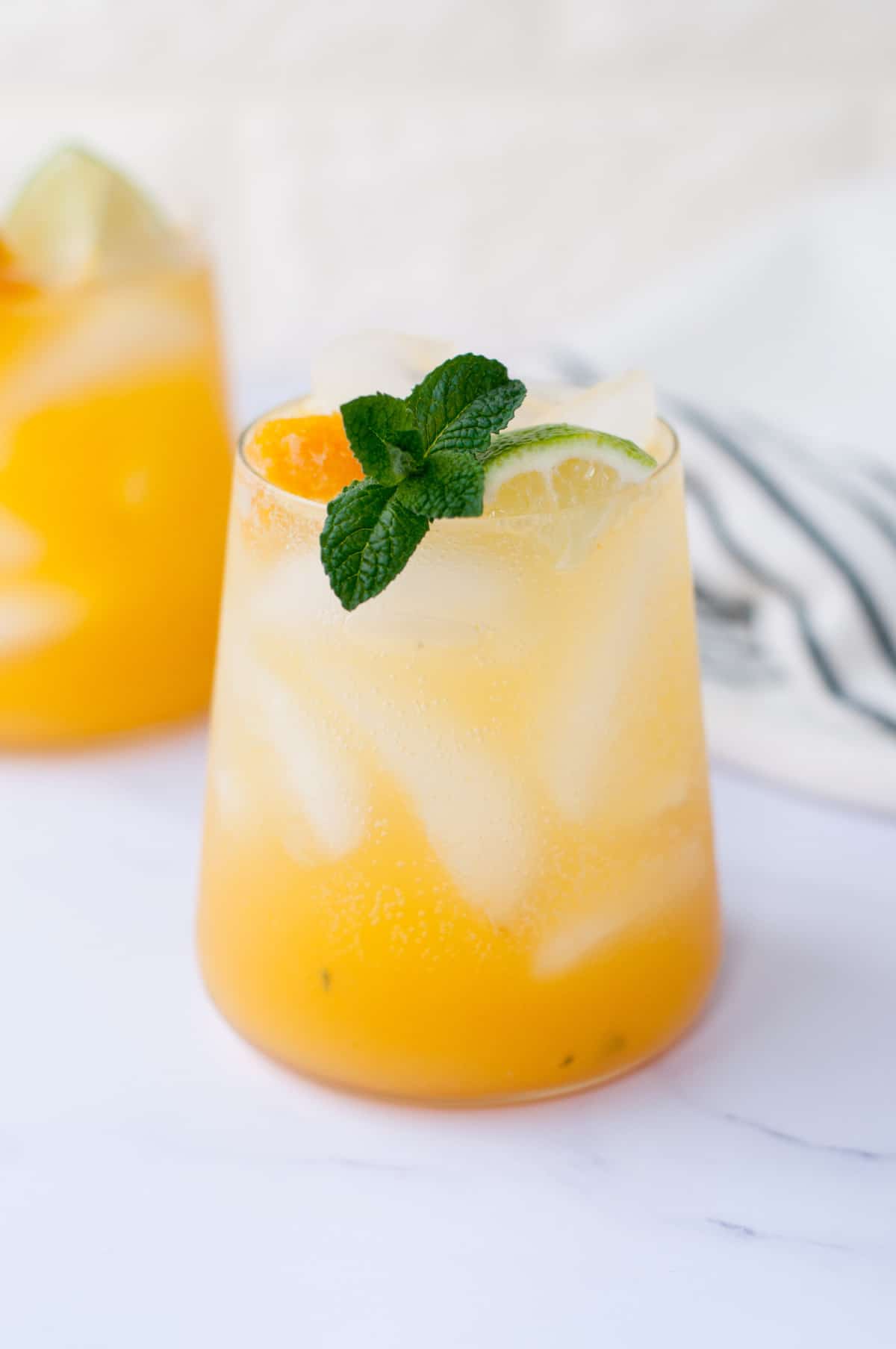 passion fruit mojito over ice, garnishes with lime mint and passion fruit, served with a stainless steel straw