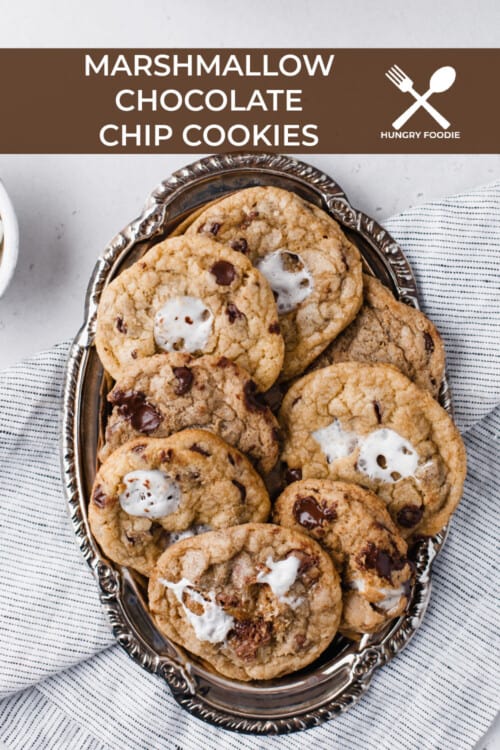 a pile of chocolate chip cookies with mini marshmallows and chocolate chips around it