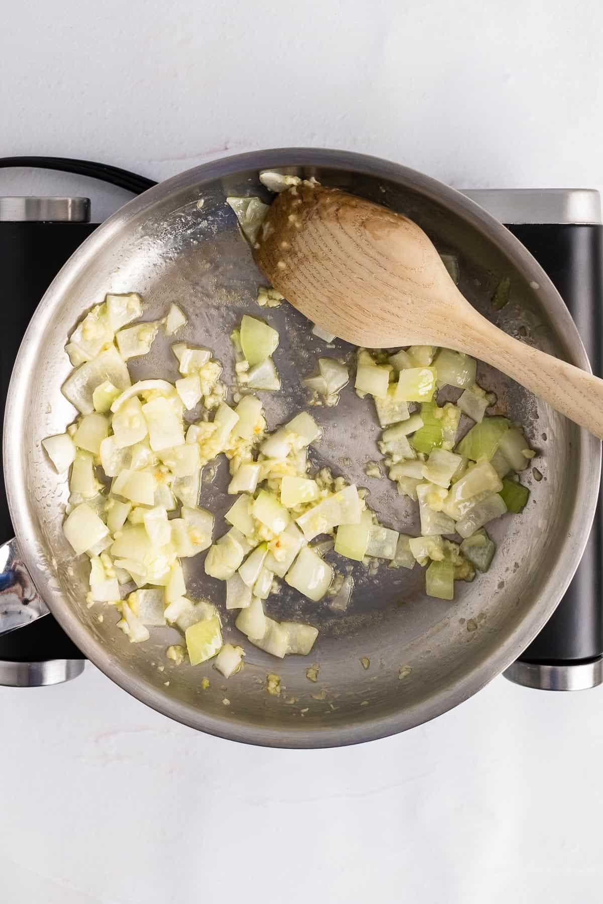 skillet with onions and garlic sautéing in butter