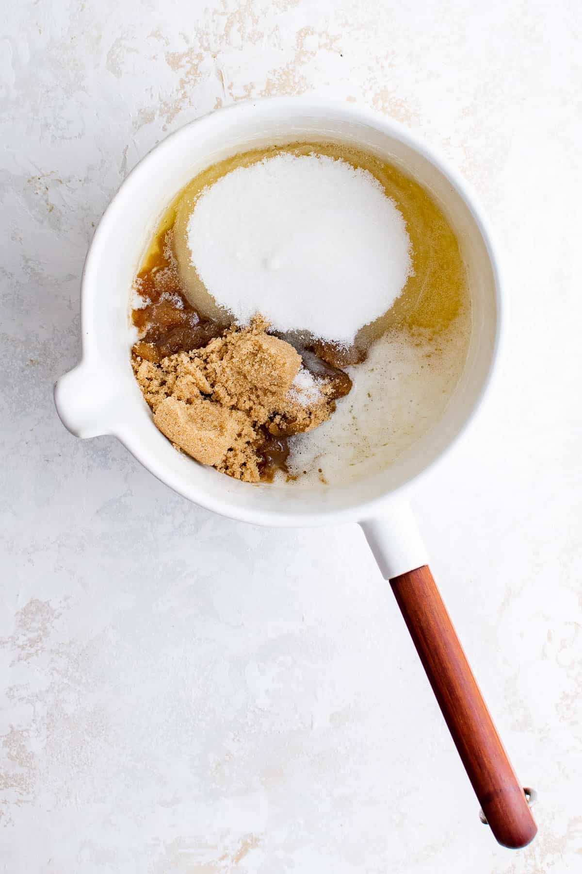 a saucepan with melted butter, white sugar and brown sugar in it