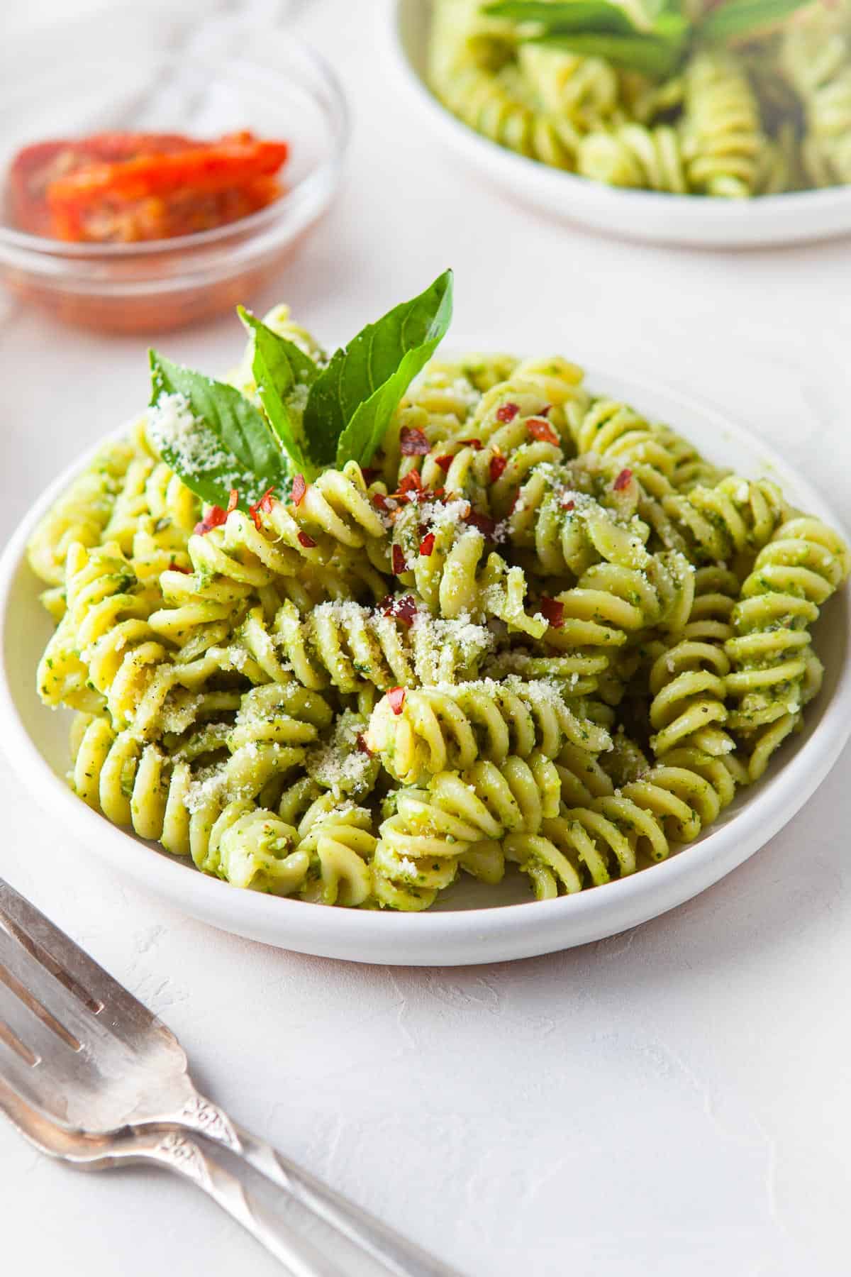 a white bowl full of homemade vegetarian pesto pasta
