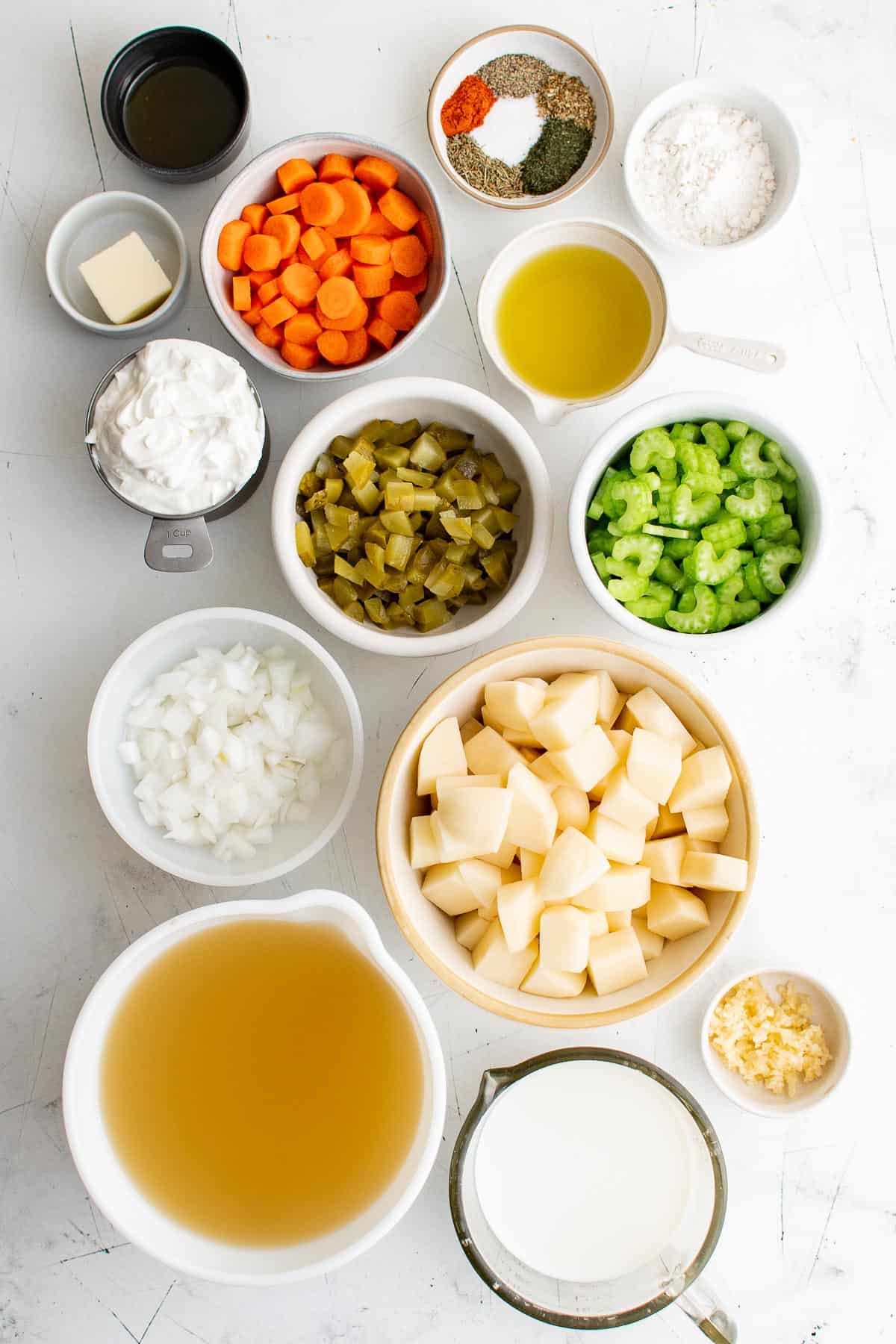 ingredients for soup - potatoes, pickles, celery, onion, carrot, broth, garlic, salt, butter, cream