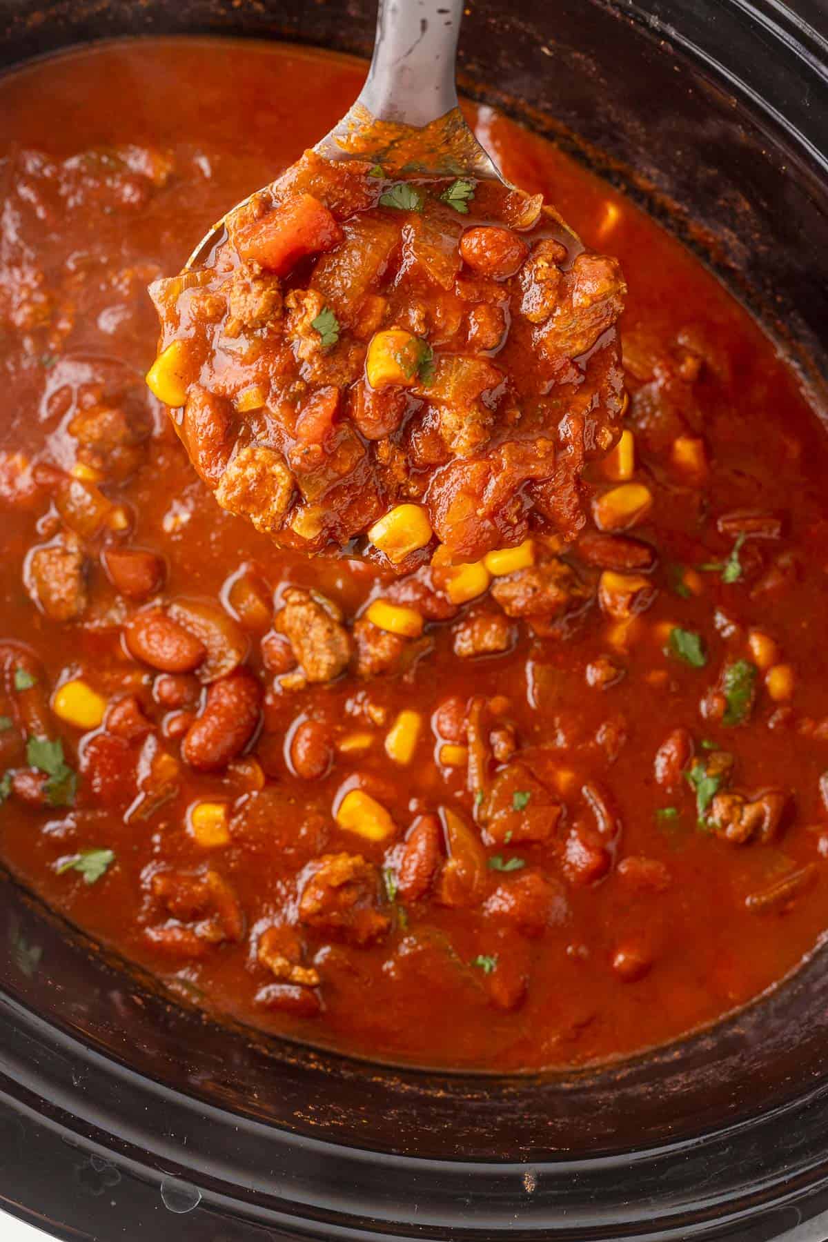slow cooker full of homemade turkey chili with a ladle