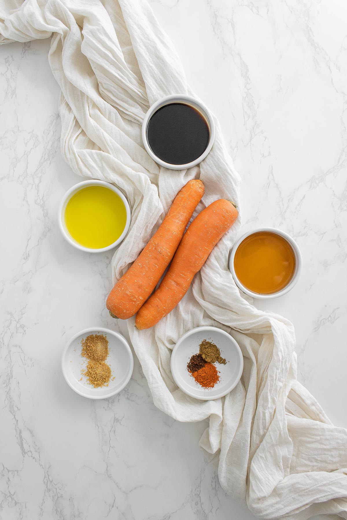 ingredient laid out to make vegan bacon - carrots, soy sauce, olive oil, maple syrup, liquid smoke and spices.