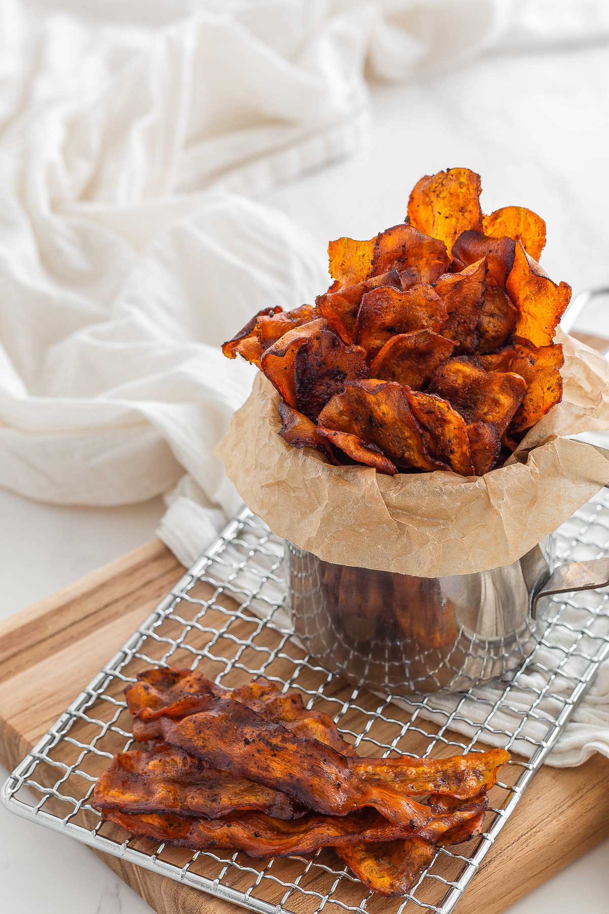 bacon made out of carrots served on a cooling rack and in a metal dish lined with parchment paper.