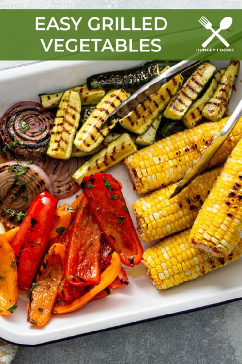 a rimmed baking sheet with grilled corn, red onion, bell peppers, and zucchini.