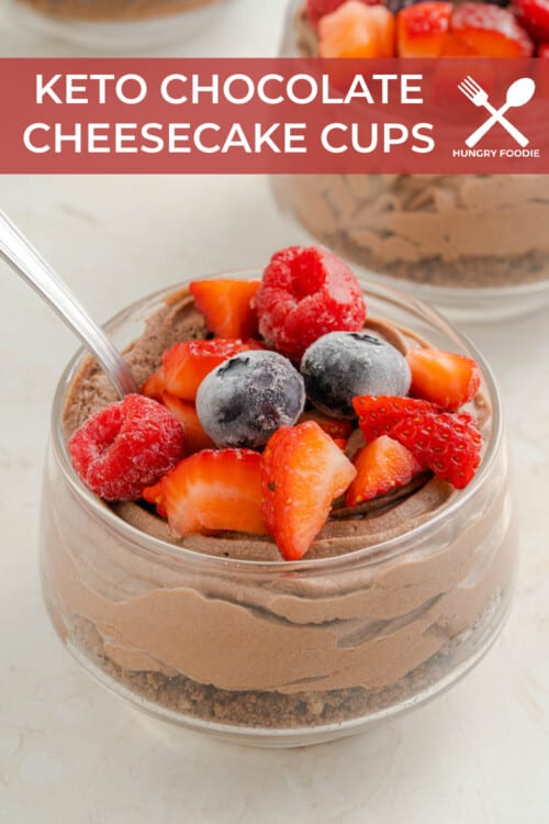 a glass jar full of chocolate cheesecake mousse, topped with frozen mixed berries.