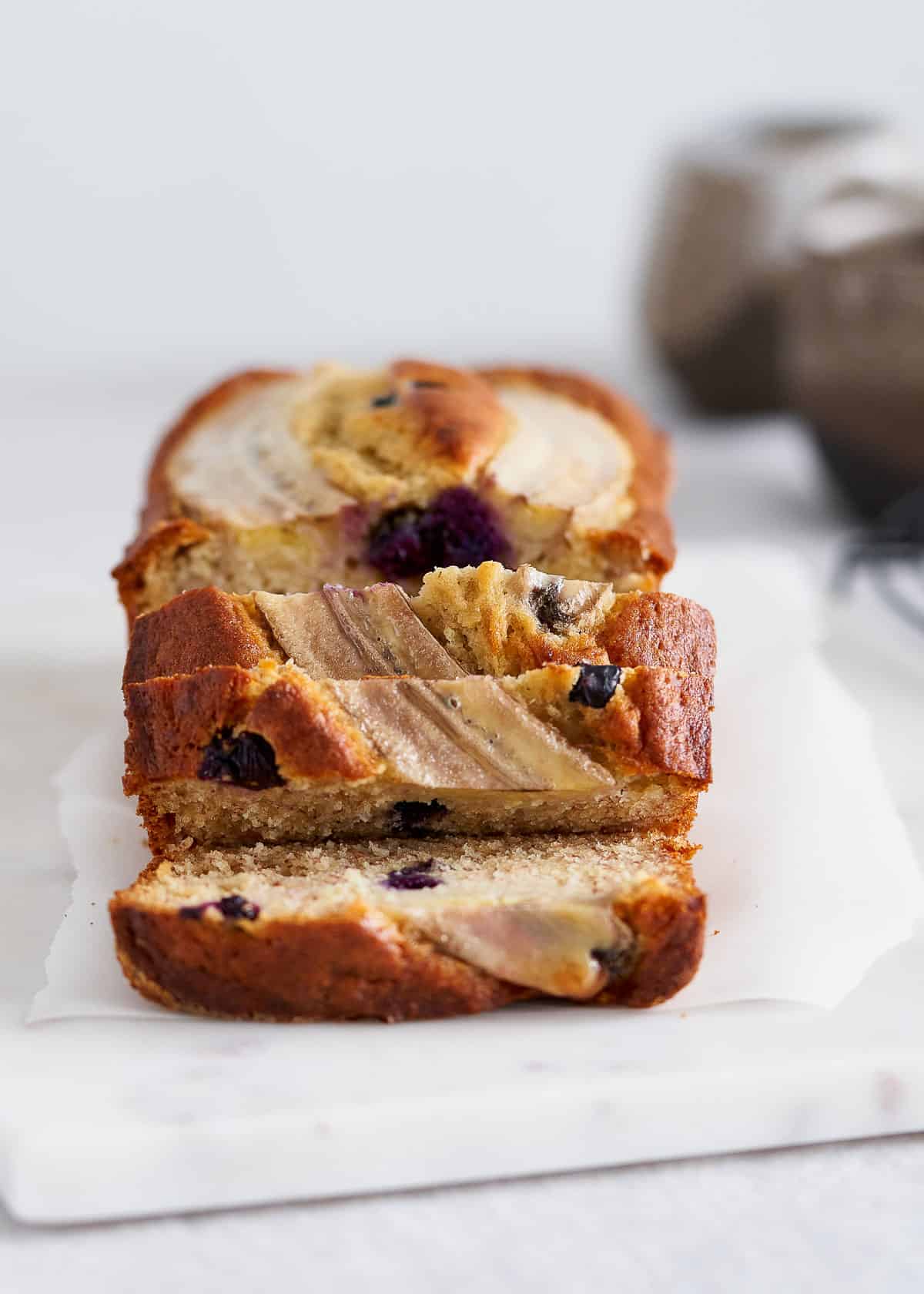 A loaf of blueberry banana bread, right out of the oven and sliced.
