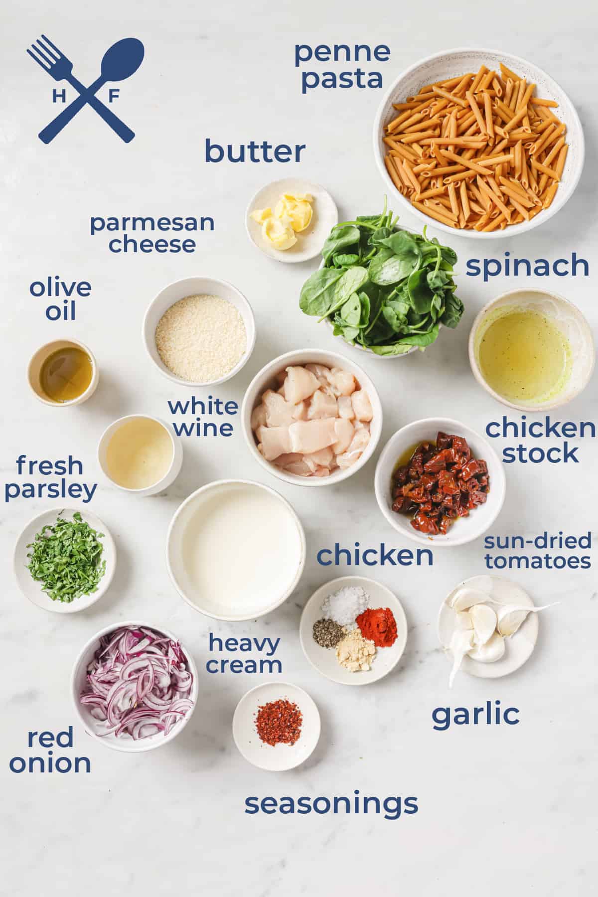 Ingredients all laid out to make a pasta dish - penne, chicken, white wine, spinach, garlic, seasonings, red onions, cream, butter, and olive oil.