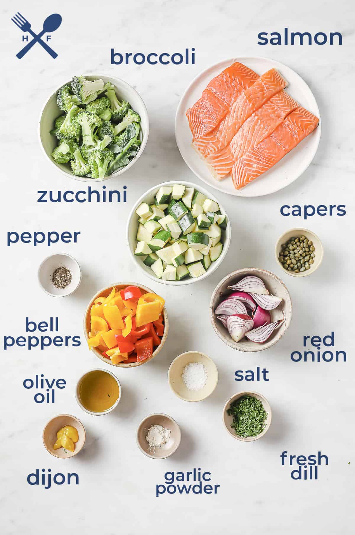 Ingredients laid out in separate bowls to make a sheet pan meal - salmon, broccoli, red onion, peppers, zucchini, dill, capers, and seasonings.